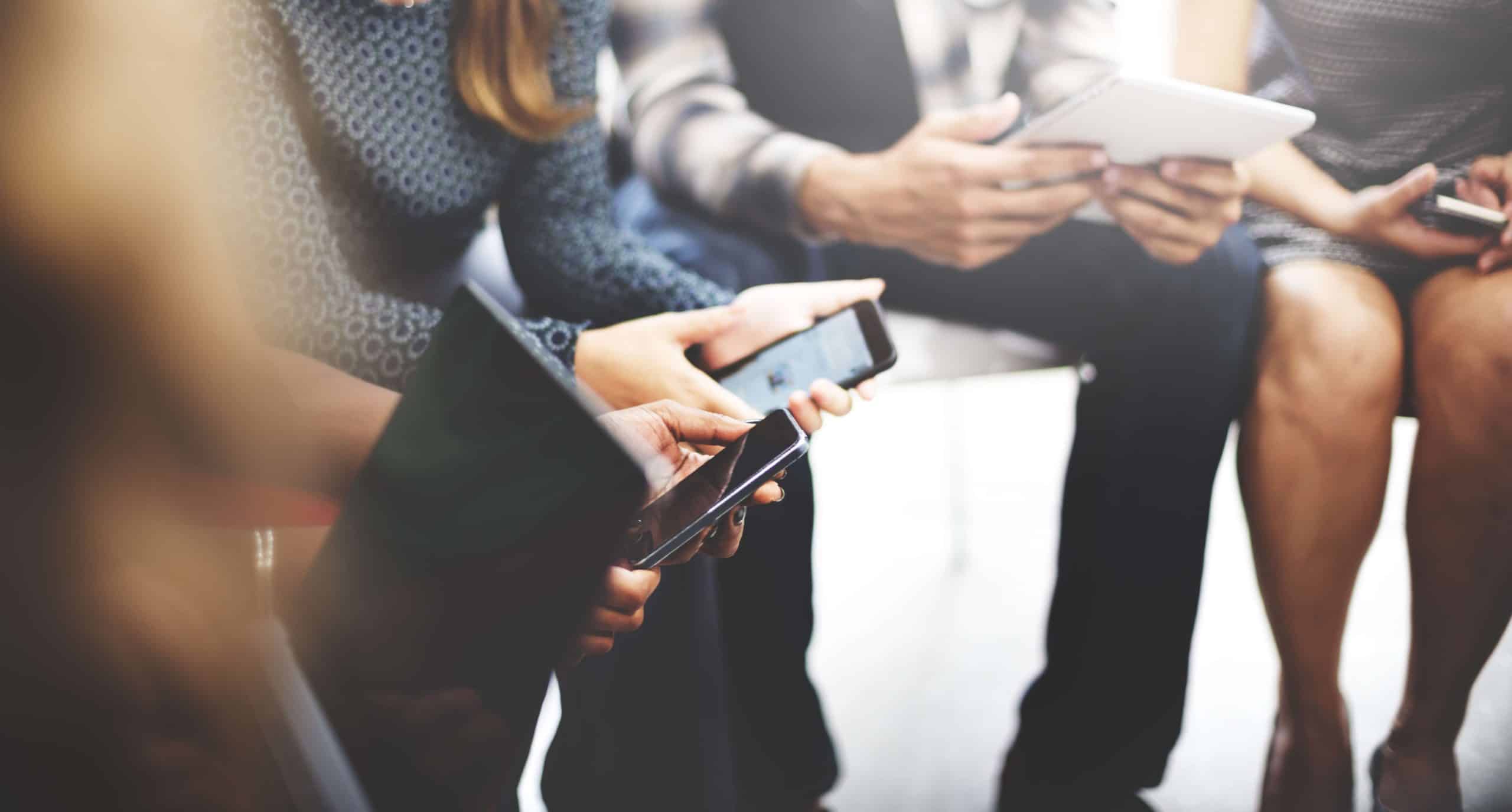 Image of people using phones and tablets for the digital marketing blog.